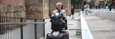 Mann som kjører Comet Ultra scooter i byen