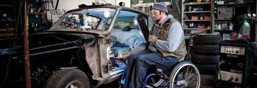 Manual wheelchair XLT Max blue ramme man working on a car
